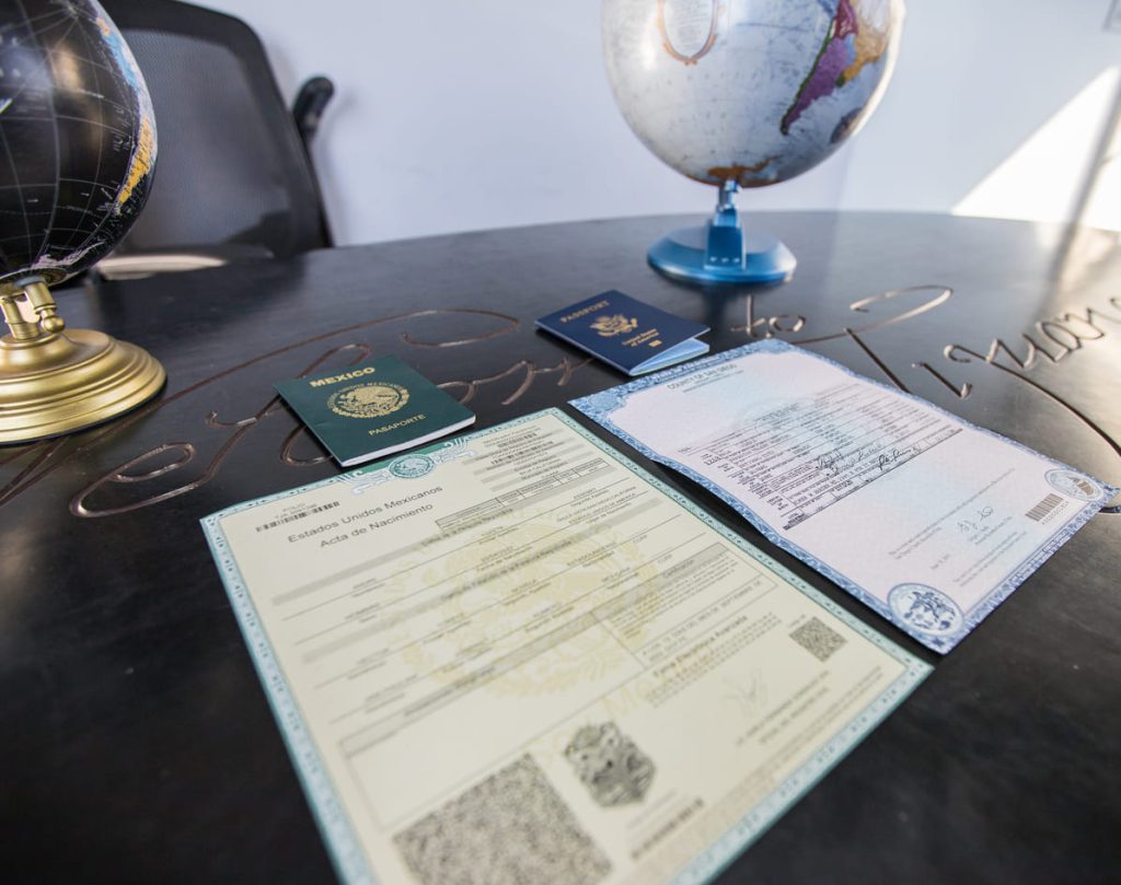 Mexican birth certificates and passports laid out on a table